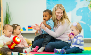 daycare woman smiles at four children